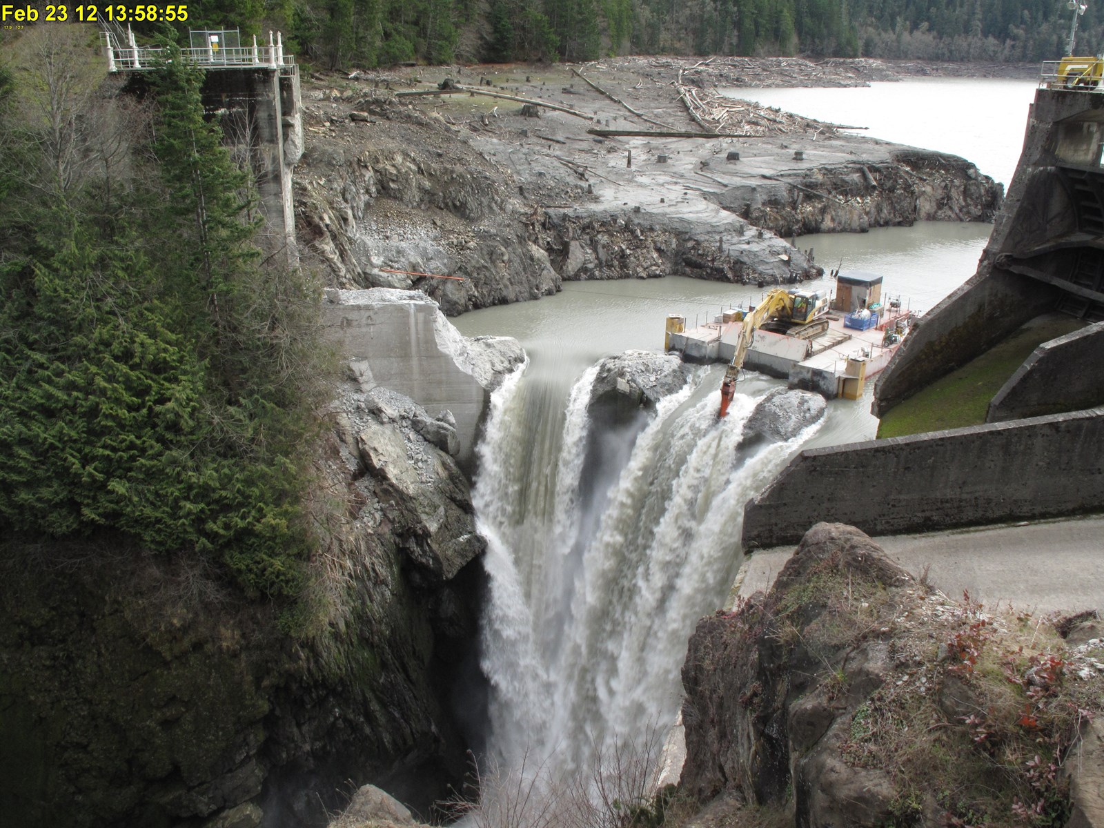 Glines Canyon Dam partly removed with a working excavator above the river